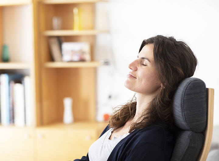 Young woman sitting at home, enjoying the moment Young woman relaxing at home